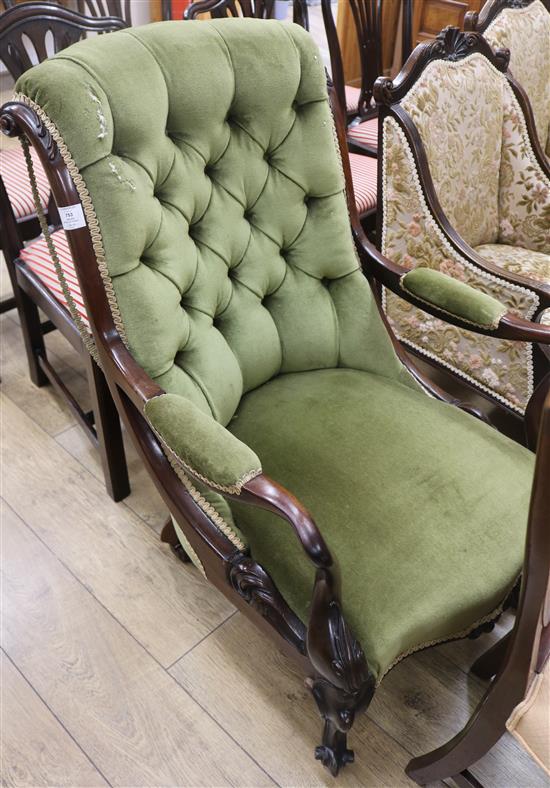 A green upholstered buttonback armchair